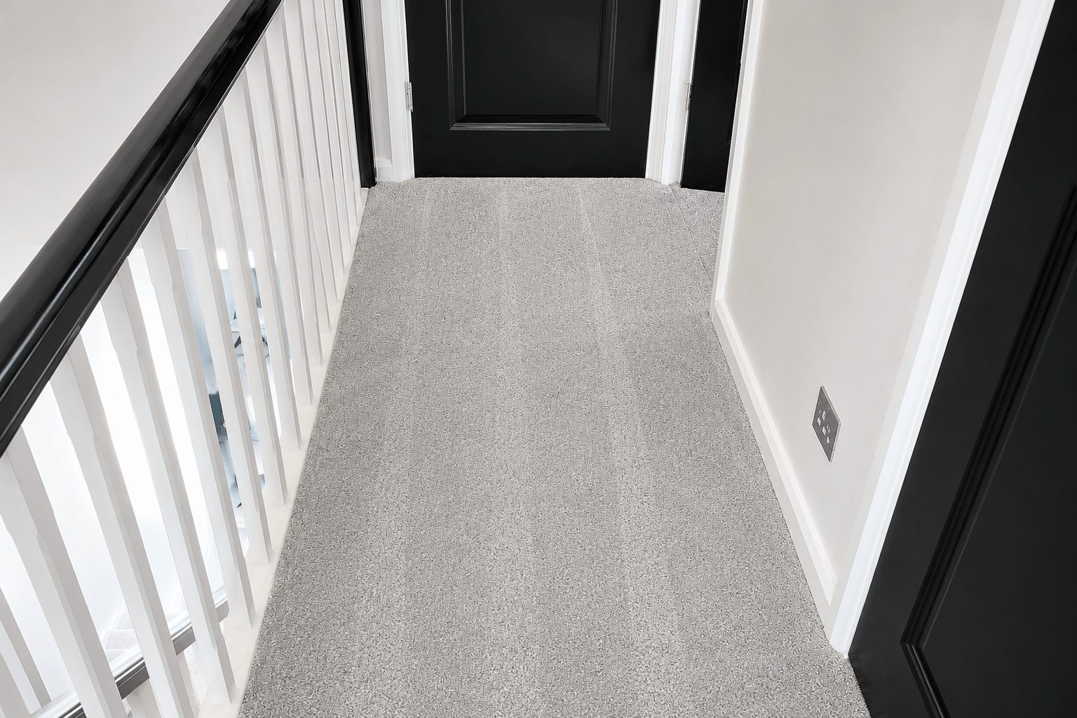 Freshly cleaned light grey hallway carpet after a professional carpet cleaning service, with visible vacuum lines and a spotless finish.