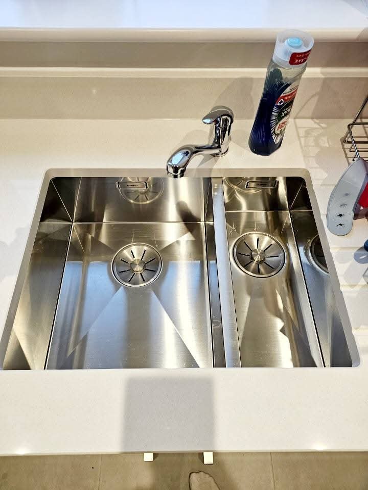 Freshly cleaned kitchen sink and basin with a spotless stainless steel